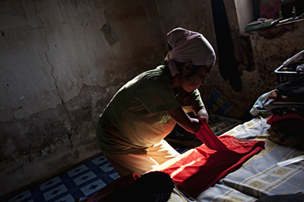 PURWOREJO, INDONESIA - MARCH 13: Armless professional photographer Rusidah, 44, folds laundry inside her house cum studio on March 13, 2012 in Purworejo, Indonesia. Rusidah shoots weddings and parties and has a small studio at home in the village of Botorejo, Bayan District, Purworejo, Central Java where her husband and son also reside. She has been in the photography business for nearly 20 years. (Photo by Ulet Ifansasti/Getty Images)